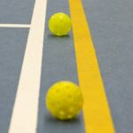 three yellow balls sitting on a tennis court